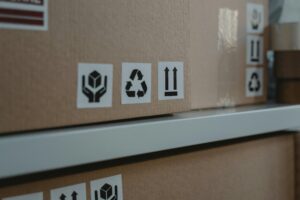 Close-up of cardboard boxes displaying shipping and recycling symbols, ideal for logistic themes.